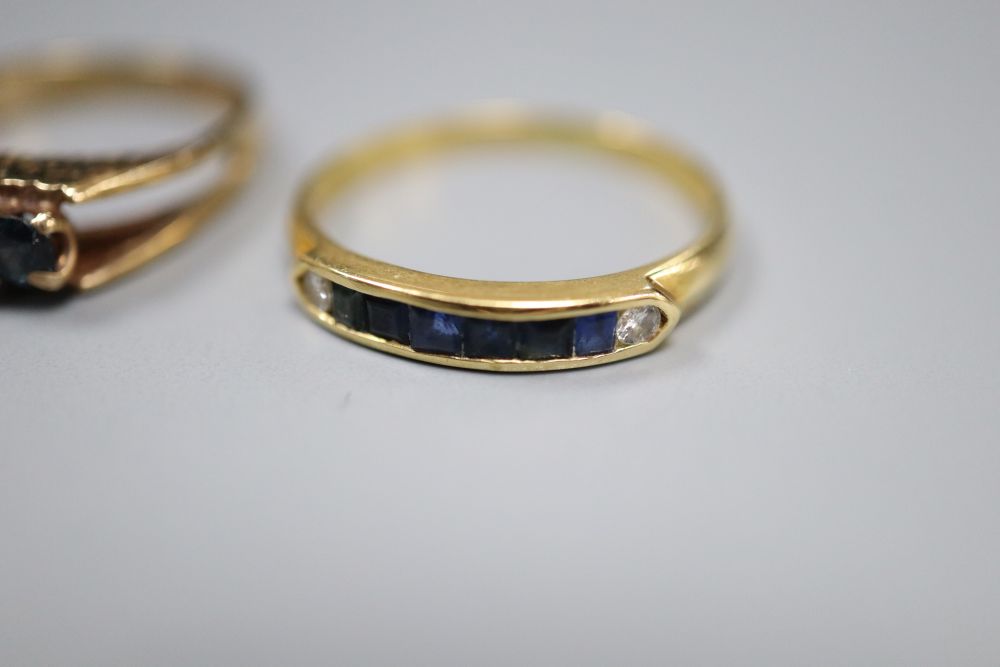 An 18ct gold, emerald and diamond asymmetric ring, an 18ct channel-set sapphire and diamond half-eternity ring and two 9ct rings